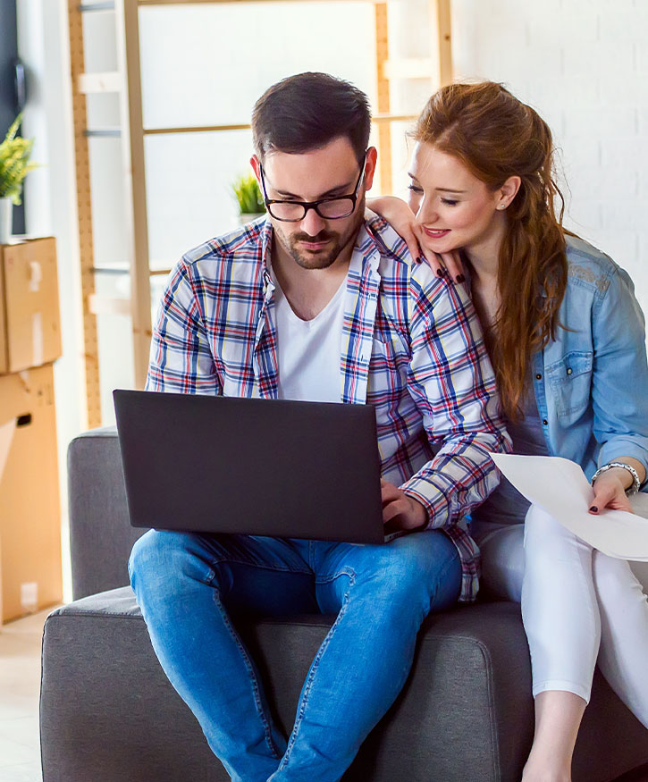 A couple on a computer messaging Cardinal Leasing for a quote on equipment leasing.